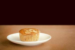 läcker banan cup cake på vit skål och träbord med kopia utrymme. hemlagat bageri. foto