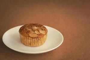 läcker banan cup cake på vit skål och träbord med kopia utrymme. hemlagat bageri. foto