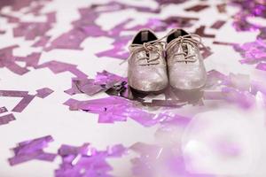 baby snygga skor på vit bakgrund med färgglada konfetti en copyspace. plats för inskription. foto