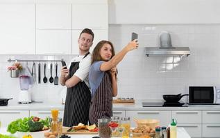 ungt par selfie medan du lagar mat i köket foto