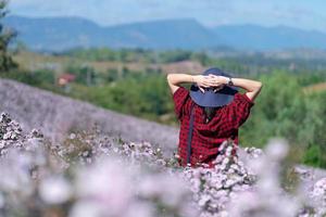 kvinna som går i rosa amarantfält på sommaren foto