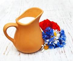 kanna mjölk och vilda blommor foto