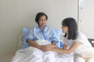senior patient kvinna och hennes stödjande dotter på sjukhus, hälsa och försäkring koncept. foto