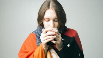 vinter flicka dricka te eller kaffe för att värma upp. foto