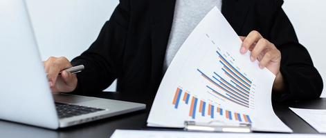 finansiella affärsmän analyserar grafen över företagets resultat för att skapa vinster och tillväxt, marknadsundersökningsrapporter och inkomststatistik, finans- och redovisningskoncept. foto
