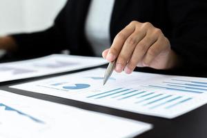 finansiella affärsmän analyserar grafen över företagets resultat för att skapa vinster och tillväxt, marknadsundersökningsrapporter och inkomststatistik, finans- och redovisningskoncept. foto