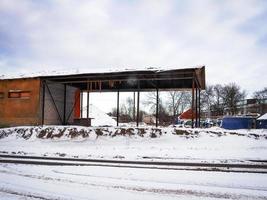 gammalt övergivet öppet lagerhus på vintern på blå himmel bakgrund med couds foto