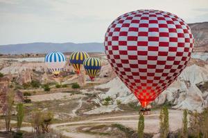 luftballong flyger över stenlandskap i Turkiet. Kappadokien foto