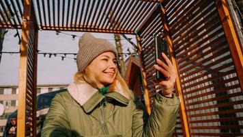 ung kvinna ler gör selfie med smartphone på staden. foto