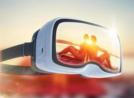 virtuell verklighet headset, dubbel exponering, romantiska par på stranden vid färgglad solnedgång bakgrund foto