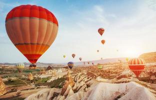 luftballong flyger över stenlandskap i Turkiet. Kappadokien foto