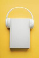 bok och vita headphones.concept av ljudbok foto