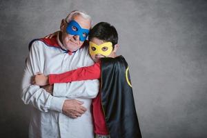 farfar med barnbarn utklädd till en superhjälte foto