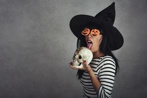 ung kvinna som håller en skalle i halloween foto