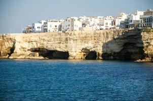 vita byggnader på grottor och klippor i staden Polignano ett sto i Puglia foto