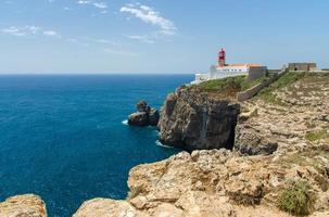 portugal, algarve, utsikt över klipporna i moher och atlanten, vit röd fyr, fyr nära sagres i portugal, udde st. vincent foto