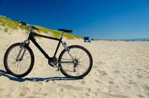 cykel på sandig gul strand, curonian spott, Östersjön, Litauen foto