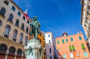 carlo goldoni monument på campo bortolomio torget mellan färgglada byggnader foto