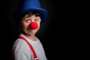 roligt barn med clownnäsa och hatt foto