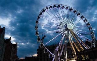 stort lysande pariserhjul framför mörkblå dramatisk himmel foto