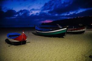 portugal, nazare strand, färgade träbåtar, panoramautsikt över nazare stad, traditionella portugisiska fiskebåtar foto