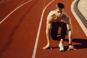 ung kille med atletisk kropp redo att springa foto