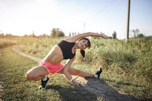 ung sport kvinna stretching och förbereder sig för att springa. foto