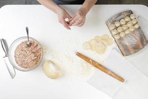 hemgjorda dumplings i köket utan dekorationer. göra dumplings med fläskfärs, nötkött och kyckling foto