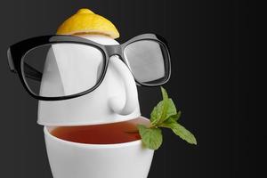 kreativ komposition på temat te. tekoppar i form av ett mänskligt ansikte med glasögon foto