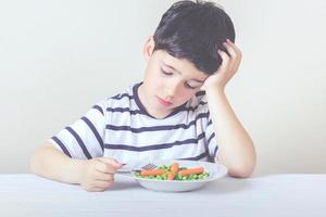 ledset barn med mat foto