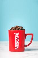 röd kopp nescafé med kaffebönor foto