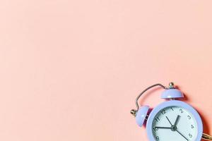 helt enkelt minimal design ringer twin bell vintage klassisk väckarklocka isolerad på rosa pastell bakgrund. vilotimmar tid av livet god morgon natt vakna vakna koncept. platt låg ovanifrån, kopiera utrymme foto