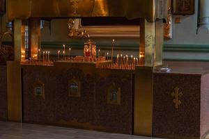 ortodox kyrka. kristendomen. festlig inredning med brinnande ljus och ikon i traditionell ortodox kyrka på påskafton eller jul. religion tro ber symbol. foto