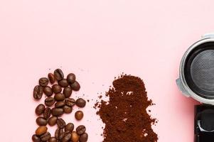detalj av filterhållare för espressomaskin, malet kaffe och kaffebönor på rosa bakgrund. utrymme för text. foto