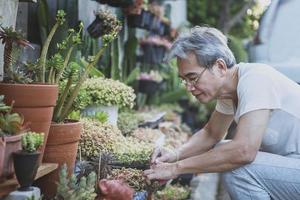 asiatisk senior man avkopplande i hemträdgården foto