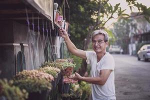 asiatisk senior man leende med lycka ansikte stående hemma trädgård foto