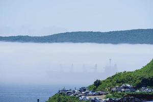 havslandskap med ett skepp i dimman. Vladivostok, Ryssland foto