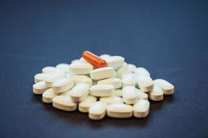 medicinska färgglada piller, kapslar eller kosttillskott för behandling och hälsovård på en svart bakgrund foto