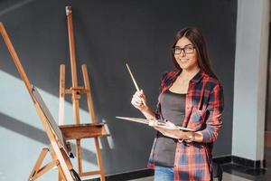 ung kvinna konstnär måla en bild i studio foto