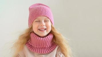 porträtt av glad liten flicka som bär stickad mössa och halsduk foto