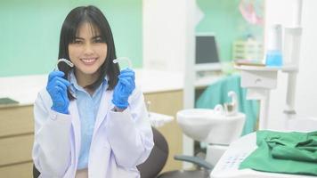 ung kvinnlig tandläkare som håller invisalign i tandklinik, tandkontroll och friska tänder koncept foto