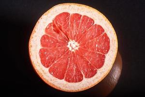färska grapefruktbitar. på svart bakgrund. foto