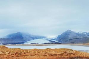 mjuka sluttningar av snötäckta berg och glaciärer. underbara island på våren. foto