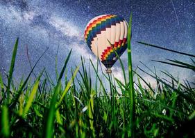 fantastisk stjärnhimmel och Vintergatan över vårens gräs och ballongbakgrund foto