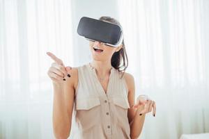 glad kvinna får erfarenhet av att använda vr-glasögon virtual reality-headset i en ljus studio foto