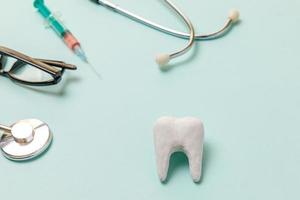 hälsotandvård koncept. medicin utrustning stetoskop vit frisk tand glasögon spruta isolerad på pastellblå bakgrund instrument enhet för tandläkare läkare. tand munhygien tandläkare dag foto