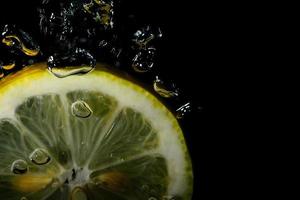 färsk citron faller i vattnet foto