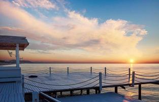 bra utsikt över den vita piren vid solnedgången, som används för naturlig bakgrund hav foto