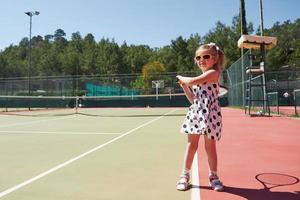 glad liten flicka spelar tennis foto