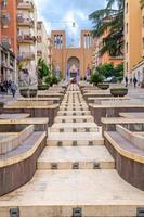 cosenza, Italien - 7 maj 2018 utsikt över den moderna trappgatan via Arabien med fontäner, mångfärgade byggnader och kyrkan Parrocchia teresa del bambino gesu, Kalabrien foto